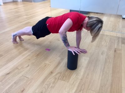 Frau im Fitnessraum während einer Übung mit der Blackroll